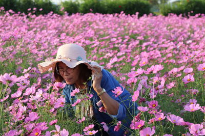 Woman with pink flowers on field