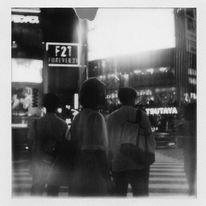 Man standing on illuminated city street at night