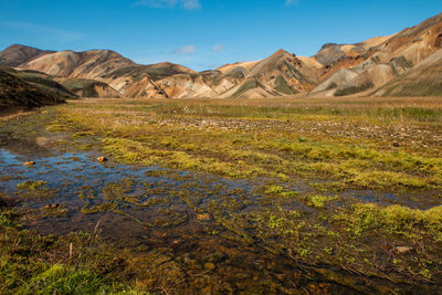 Scenic view of land and mountains against sky