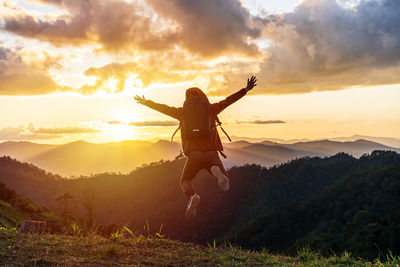 Full length of woman standing on field against sky during sunset