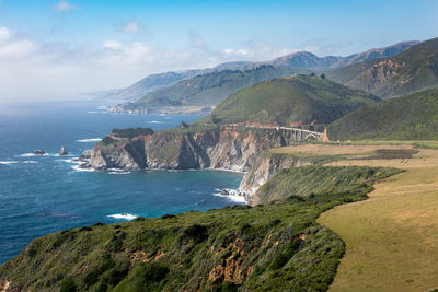 Scenic view of sea and mountains against sky