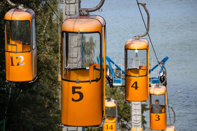 Close-up of yellow telephone booth by water