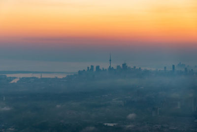 Aerial view of buildings in city during sunset