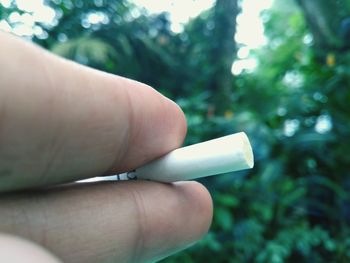 Close-up of hand holding cigarette