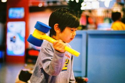 Side view of cute boy with toy