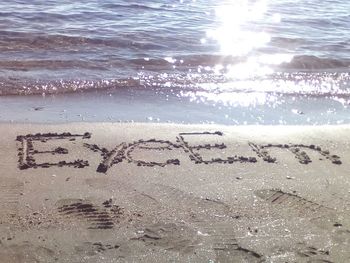 Close-up of text on sand at beach