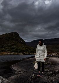 Full length of man standing on shore against sky