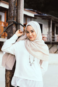 Portrait of young woman standing on cross