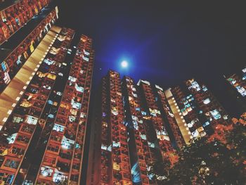 Low angle view of illuminated buildings against sky at night