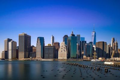 High angle view of river by cityscape against blue sky