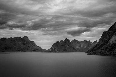 Scenic view of sea by mountains against sky