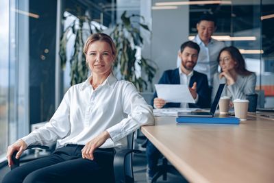 Portrait of female friends using laptop at office