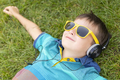 Portrait of young woman wearing sunglasses while sitting on grassy field