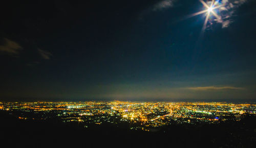 High angle view of illuminated cityscape against sky at night