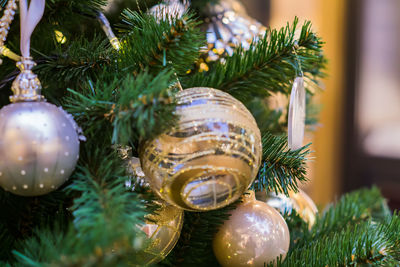 Close up of christmas tree decorated with gold and white balls and snowflake. new year background