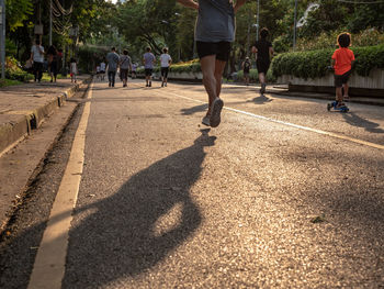 Rear view of people walking on street in city