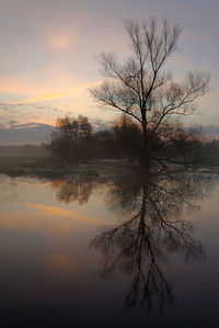 Scenic view of lake against sky at sunset