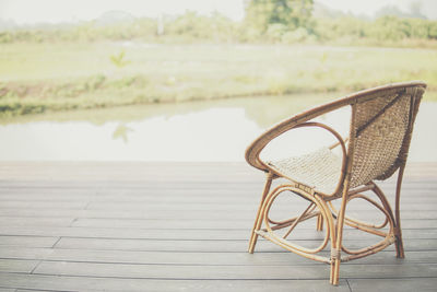 Empty chair and table by lake