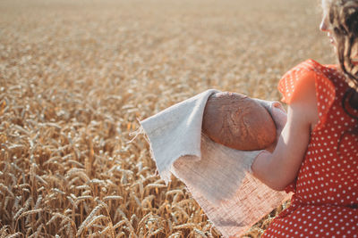 Midsection of woman with umbrella on land