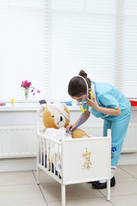 Rear view of girl with toy toys at home
