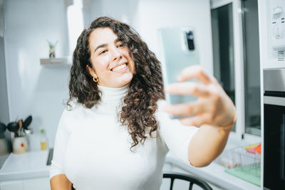 Portrait of smiling young woman using mobile phone in gym