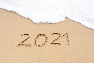 High angle view of text on sand at beach