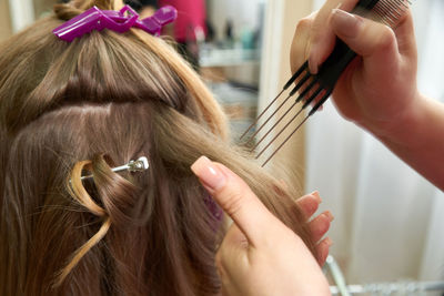 Hands of woman combing hair