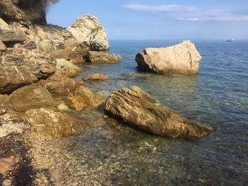 Rocks on sea shore against sky