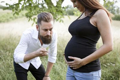 Side view of couple standing by plants