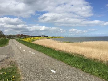 Empty road passing through field