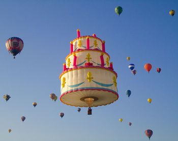 Low angle view of hot air balloons against blue sky