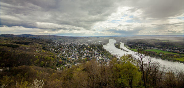 Scenic view of river flowing on landscape against cloudy sky