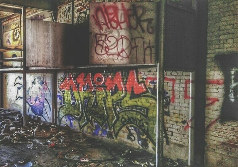 graffiti, indoors, art and craft, wall - building feature, art, built structure, architecture, creativity, abandoned, text, multi colored, no people, messy, wall, damaged, day, store, obsolete, large group of objects, retail