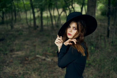 Young woman wearing hat standing on field