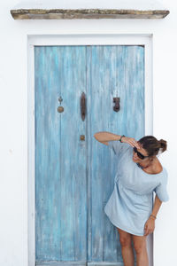 Woman standing against closed door