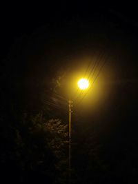Low angle view of illuminated street light against sky at night