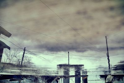 Power lines against cloudy sky