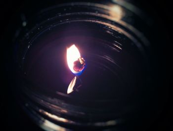 Close-up of lit candle in dark room