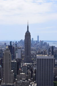 Modern buildings in city against cloudy sky