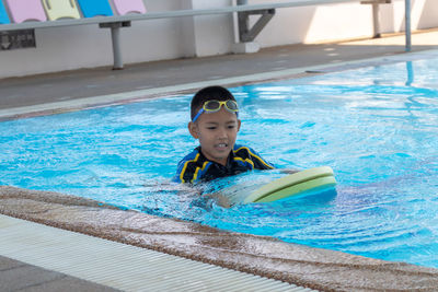 Portrait of happy boy swimming in pool