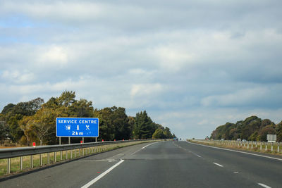 Road sign against sky