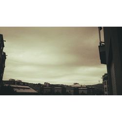 Buildings in city against cloudy sky