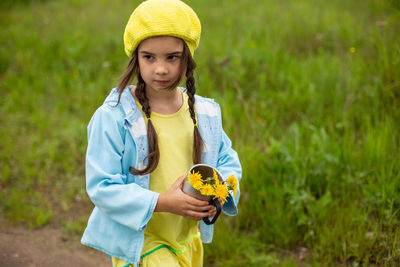 Portrait of young woman standing against plants