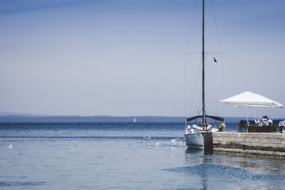 Sailboats in sea against clear sky