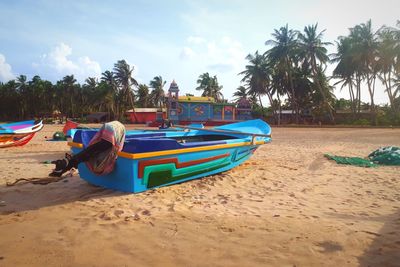 Boats moored on beach against sky