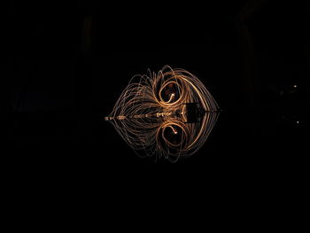 Close-up of illuminated lighting equipment against black background