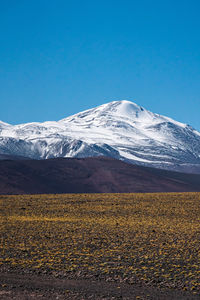 Scenic view of snowcapped mountains against clear blue sky