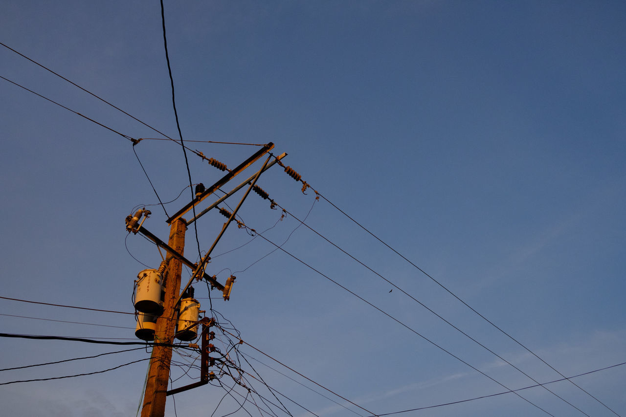 electricity, sky, low angle view, cable, connection, technology, power line, power supply, electricity pylon, fuel and power generation, nature, no people, clear sky, complexity, blue, day, outdoors, telephone pole, copy space, electrical equipment, telephone line, flock of birds