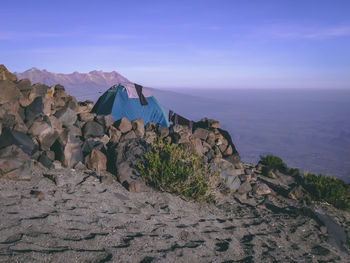 Scenic view of rocks and sea against blue sky