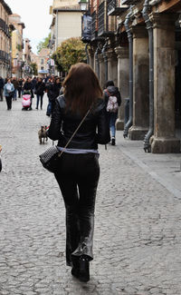 Rear view of women walking on street in city